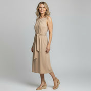woman wearing apricot maxi dress on a plain background