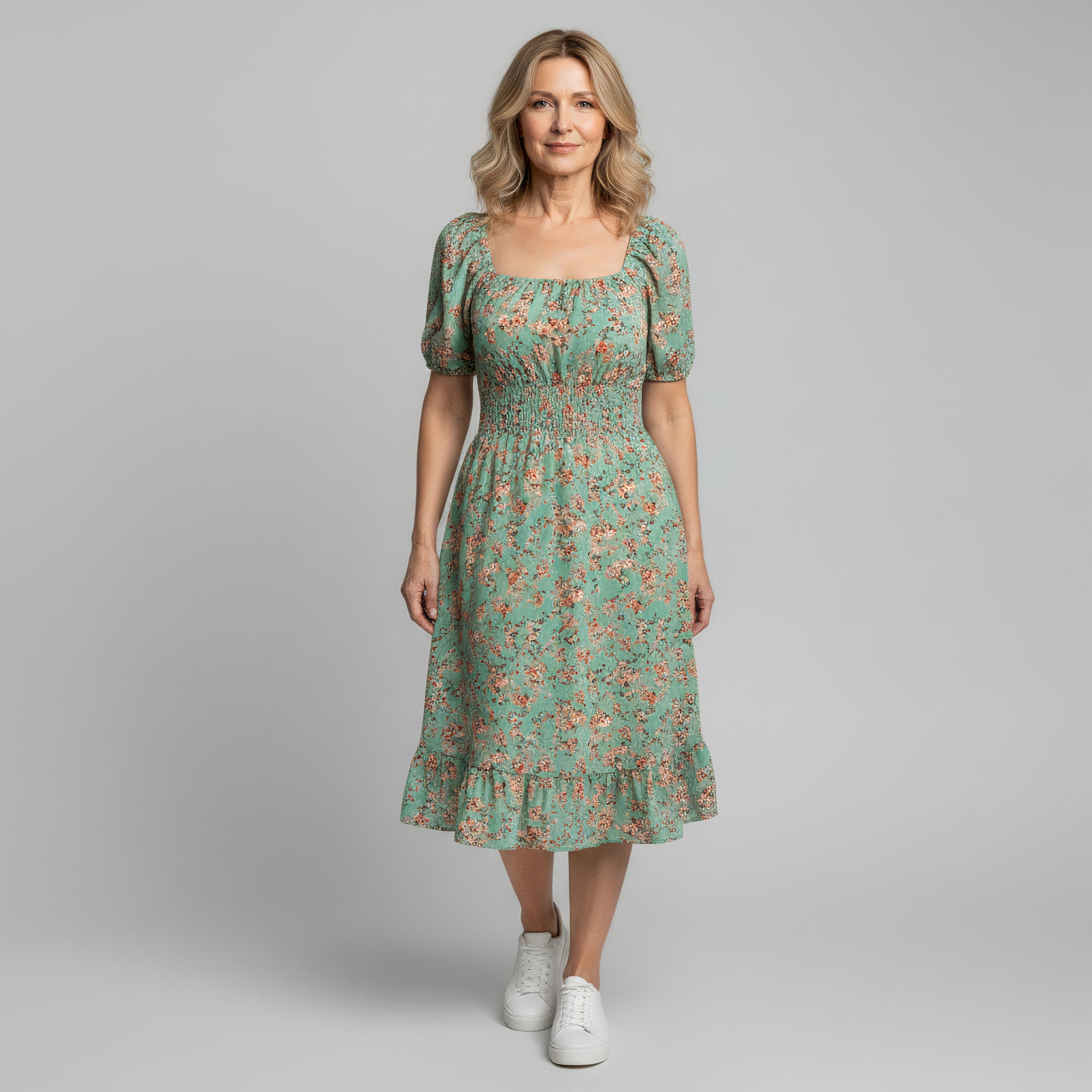 woman wearing light green floral maxi dress on a plain background