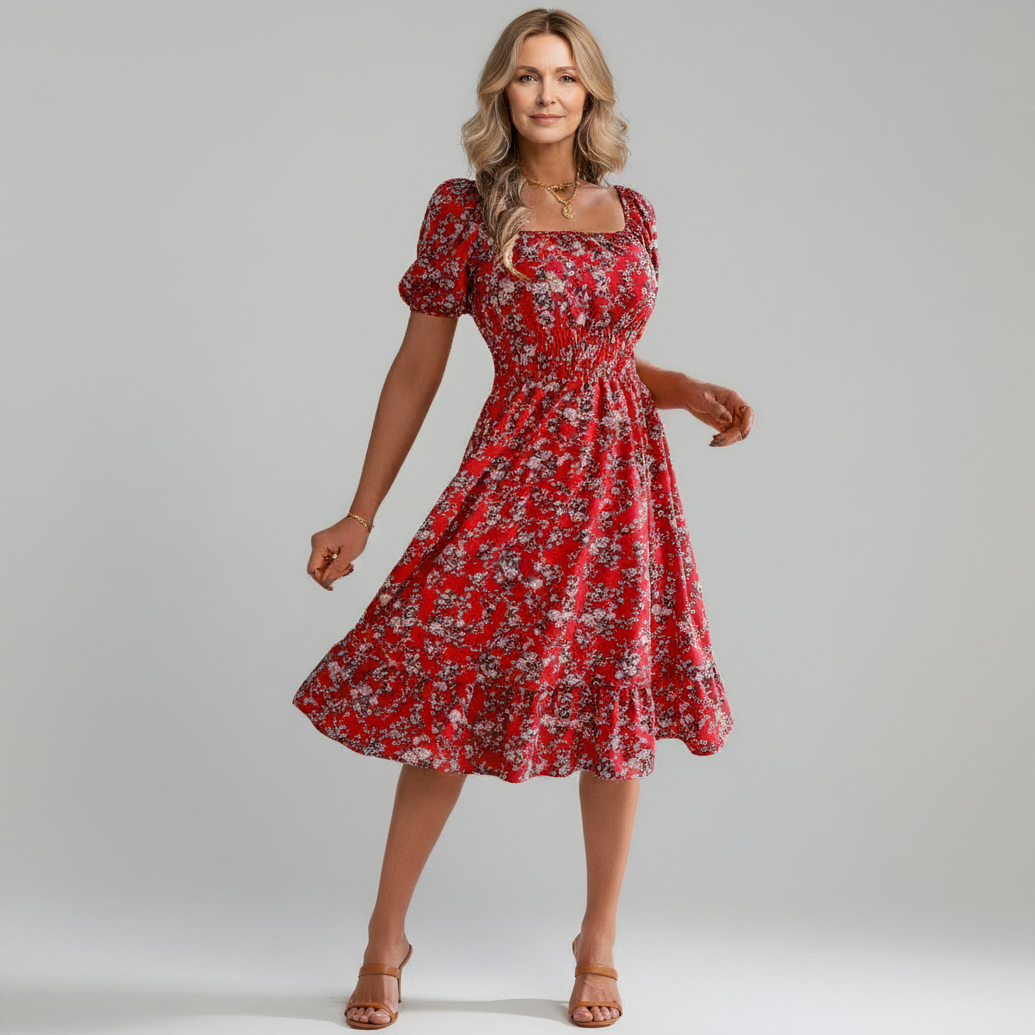 woman wearing red floral maxi dress on a plain background