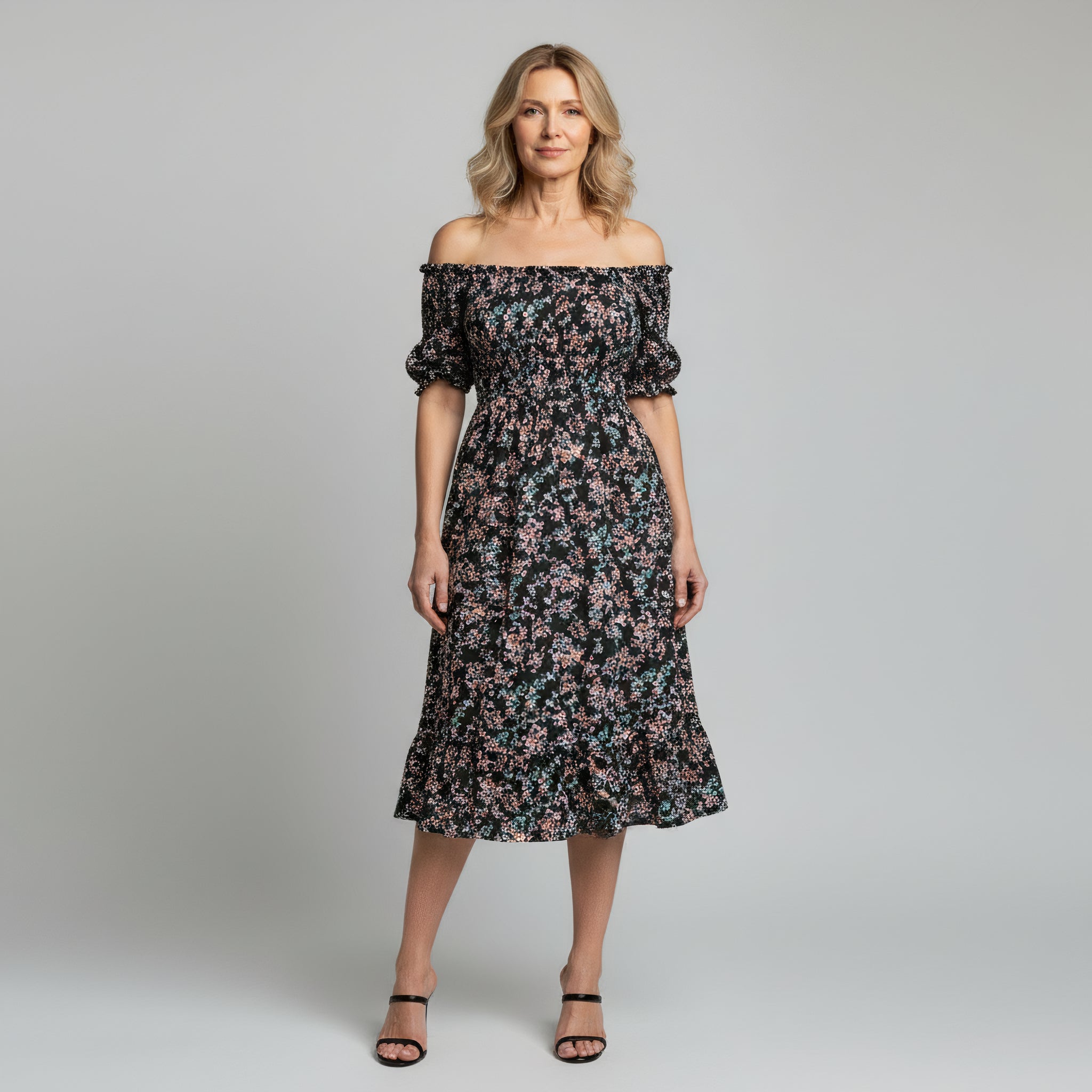 woman wearing off shoulder floral print mxi dress on a plain background