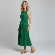 woman wearing green maxi dress on a plain background