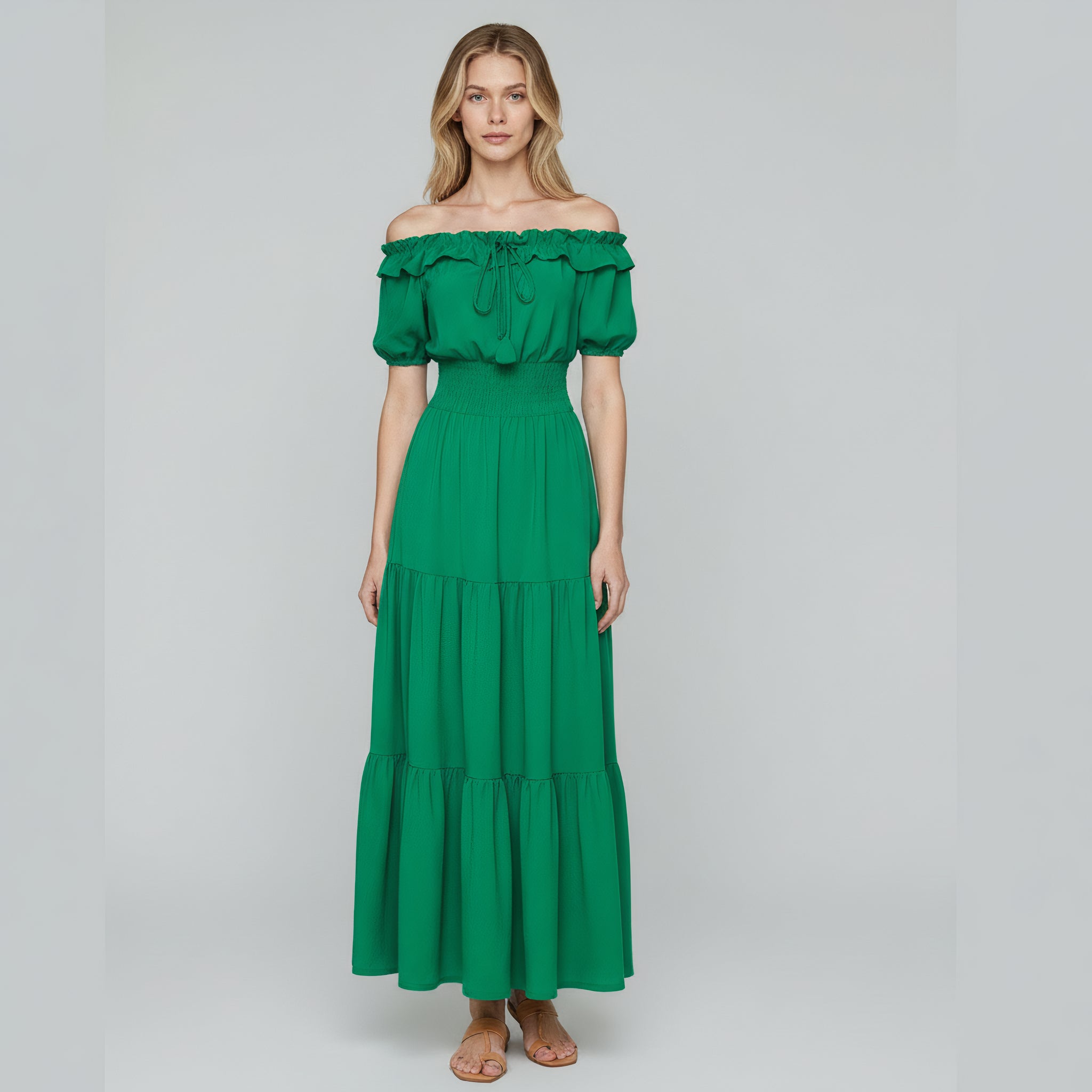 woman wearing green off shoulder maxi dress on a plain background