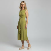 woman wearing yellow sleeveless maxi dress on a plain background